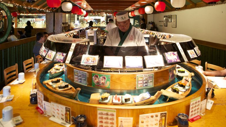 Sushi chef behind counter